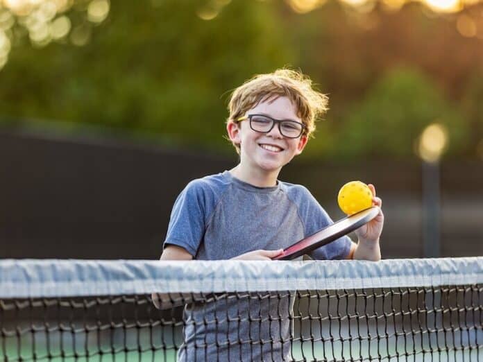 Boy on court with pickleball gear