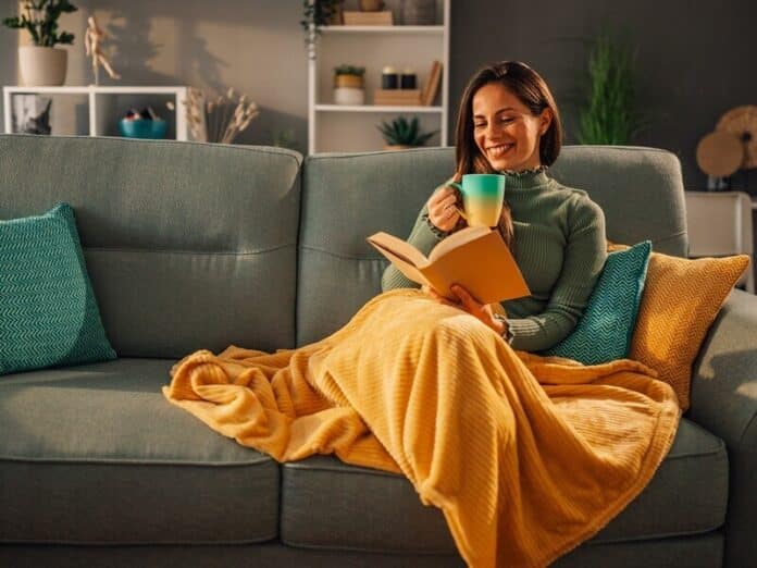 A happy woman is reading book at home. How free delivery makes shopping for furniture and appliances truly convenient