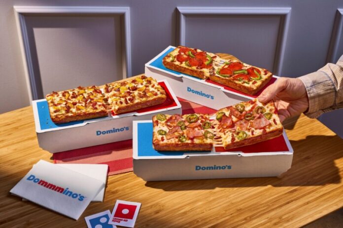 Domino-Group-Shot The Domino is made with premium, buttery-flavored pan dough encrusted with real Parmesan cheese and baked in a rectangular pan to create a crispy Parmesan Detroit-style crust. It is topped with two layers of cheese, customers' choice of sauce and up to three toppings, and finished with a drizzle of Domino's signature garlic seasoning.